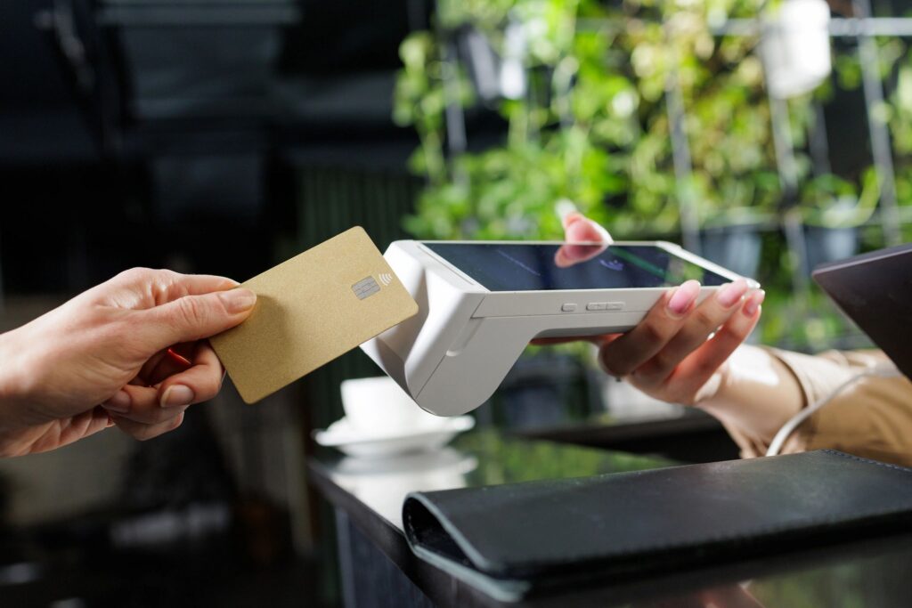 NFC contactless card payment at reception counter with handheld POS terminal